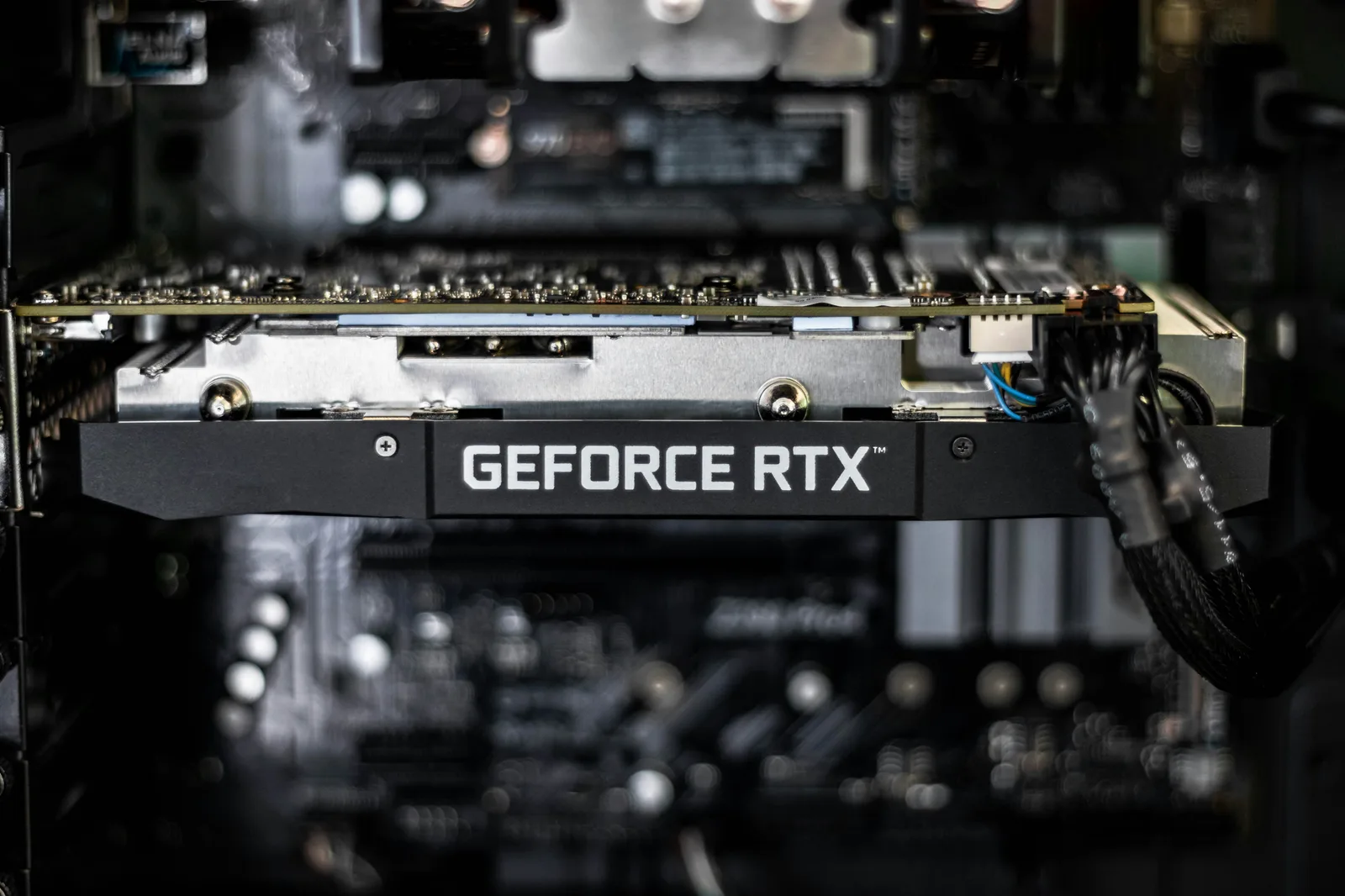 A GeForce RTX graphics card photographed in selective focus, its fans and shroud filling the frame against a dark background.